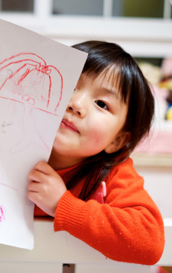 A small girl showing her art work